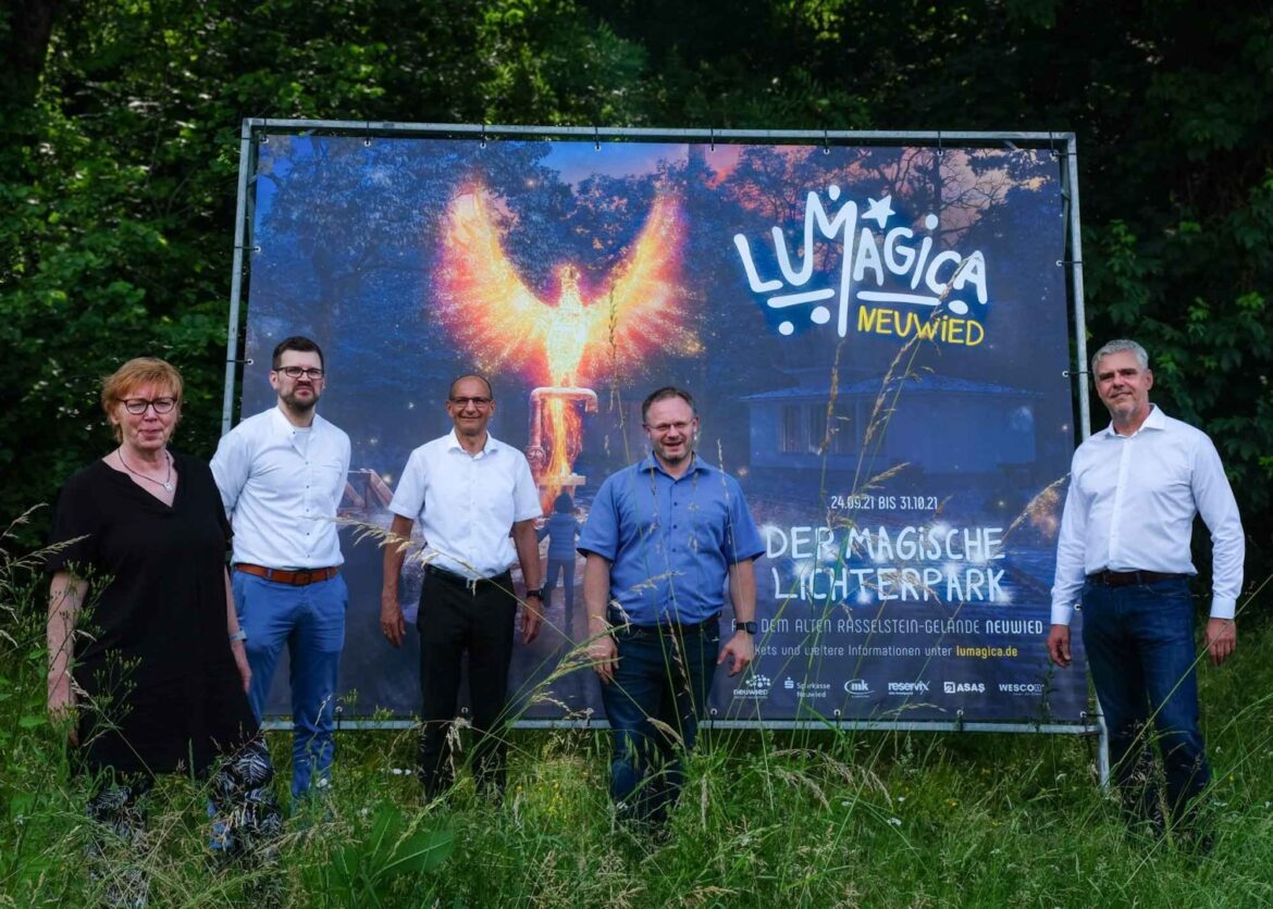 Gruppe von fünf Personen vor einem Lumagica-Banner im Freien.