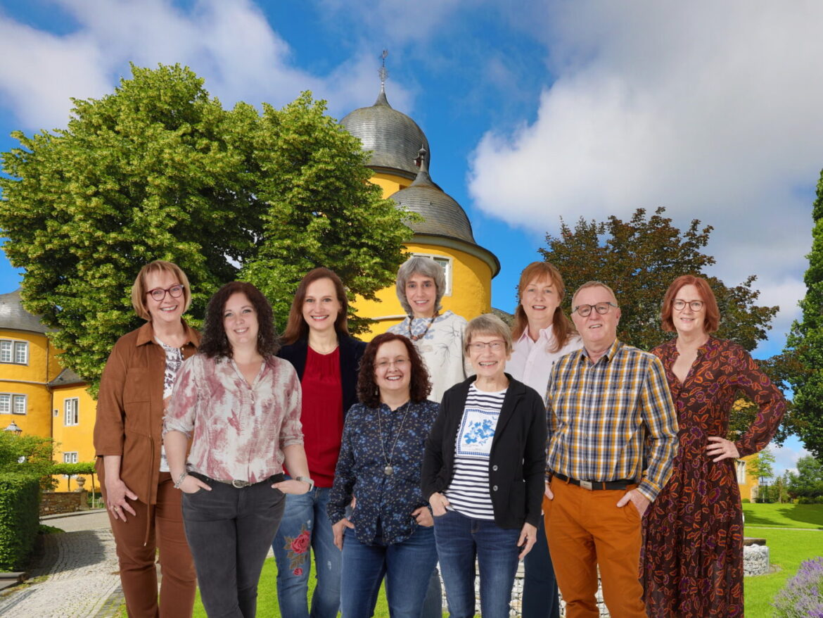 Gruppe von neun Personen vor einem historischen Gebäude.