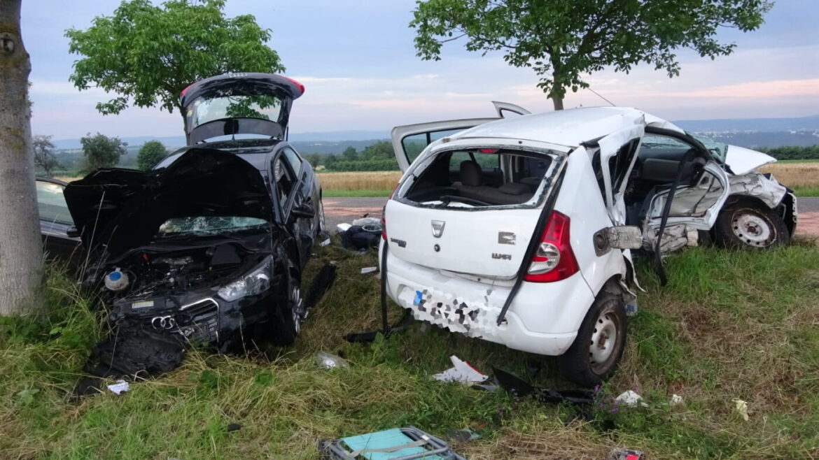Zwei beschädigte Autos nach einem Unfall auf einer Landstraße.