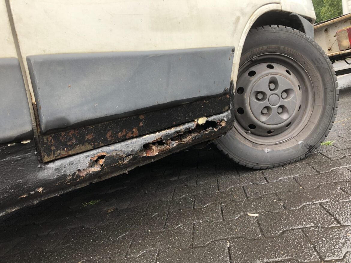 Nahaufnahme eines durchgerosteten Fahrzeugschwellers