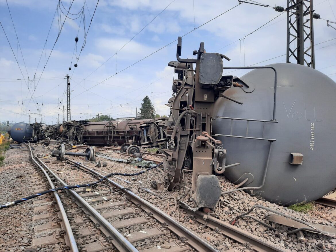 Entgleiste Güterwaggons auf Bahngleisen.