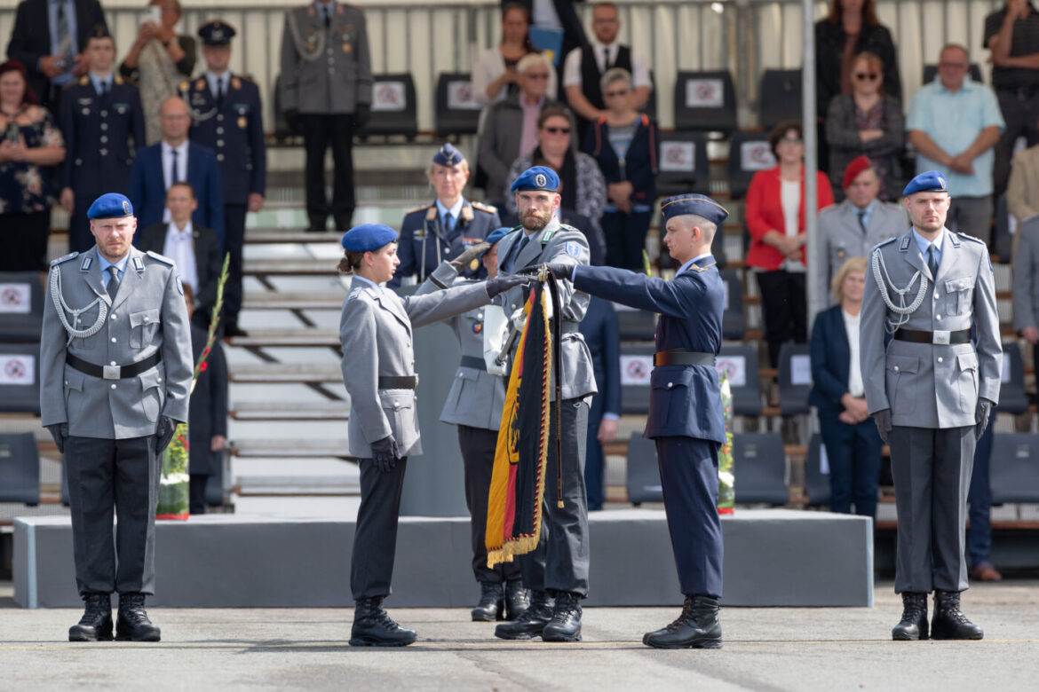 Militärzeremonie mit Soldaten in Uniformen, die eine Fahne halten.
