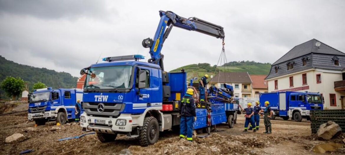 THW-Fahrzeuge und Einsatzkräfte bei einem Einsatz in einem Dorf.