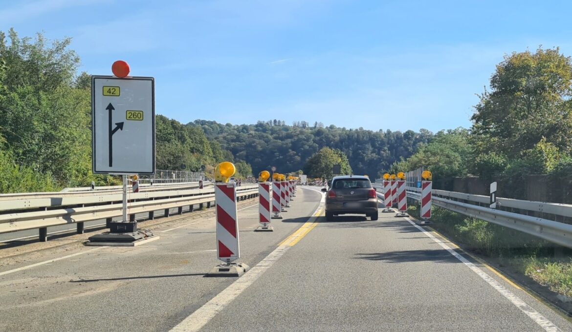 Auto fährt durch Baustelle auf Landstraße mit Verkehrsschildern.