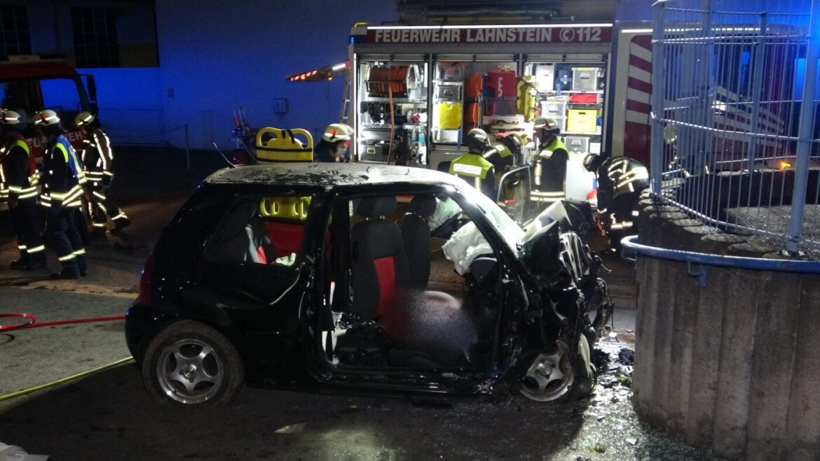 Unfallfahrzeug mit Feuerwehrleuten bei Nacht