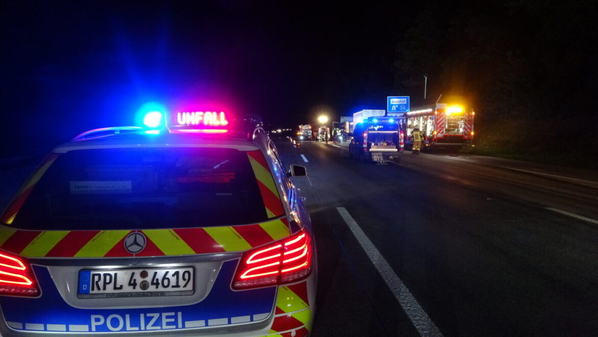 Polizeiwagen und Einsatzfahrzeuge bei Nacht auf einer Straße.
