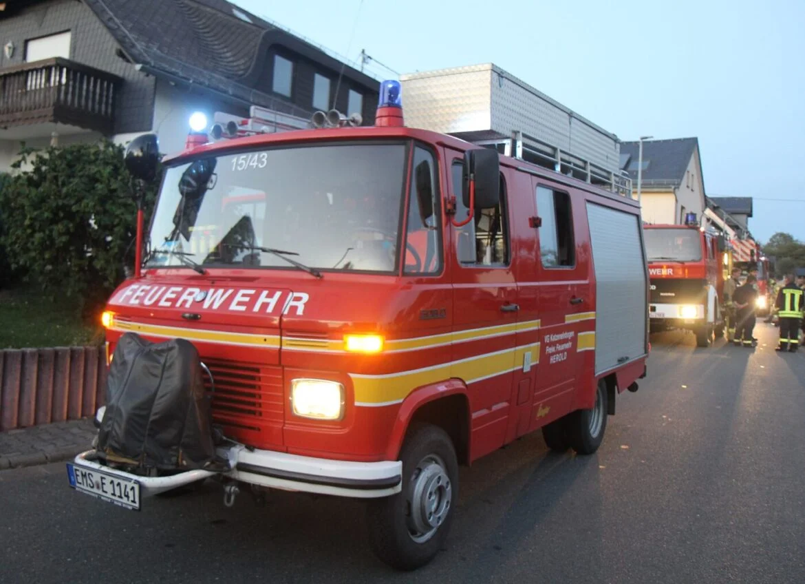 Feuerwehrauto auf einer Straße in einem Wohngebiet.