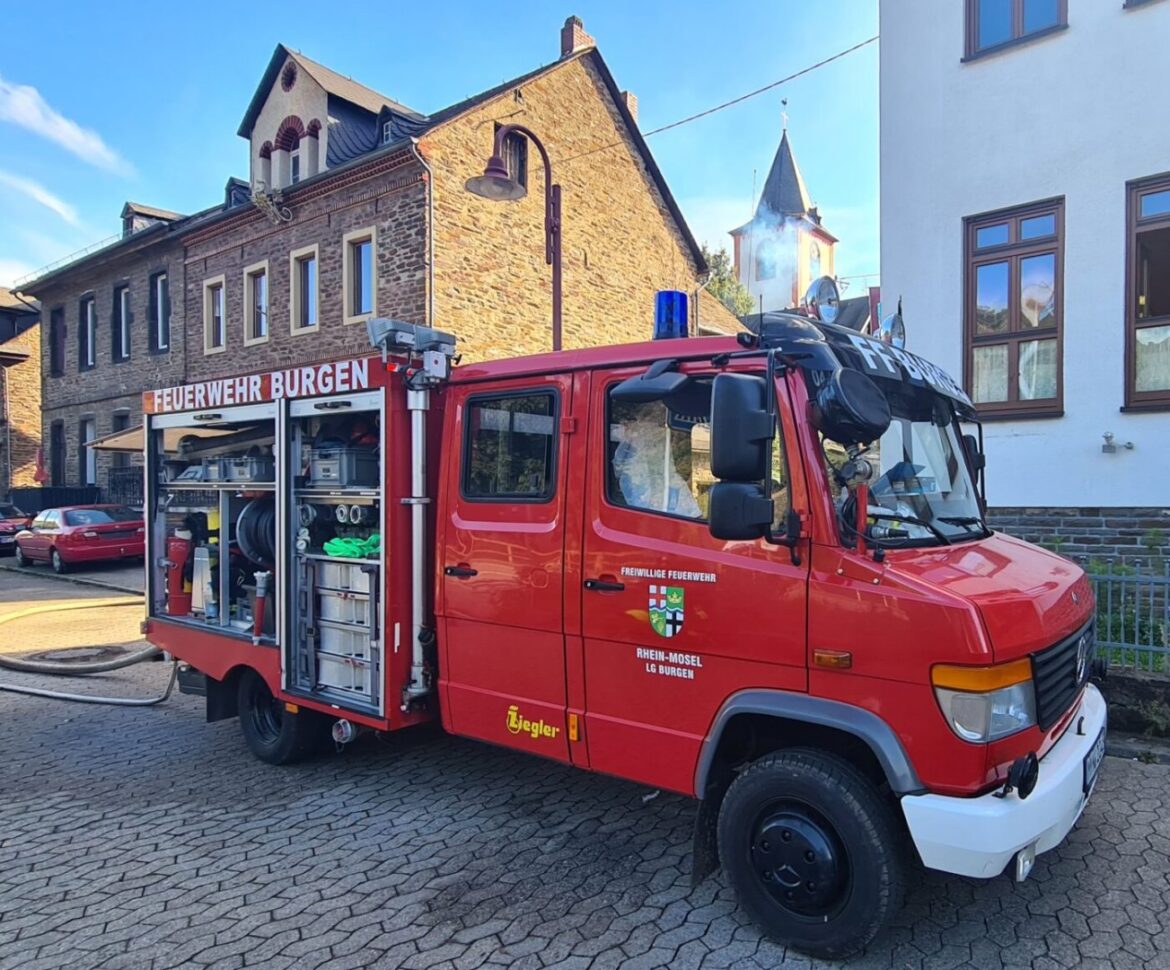 Rotes Feuerwehrfahrzeug in einer deutschen Stadt.