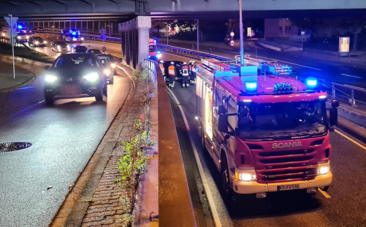 Feuerwehrauto und Polizei bei einem nächtlichen Einsatz auf einer Straße.