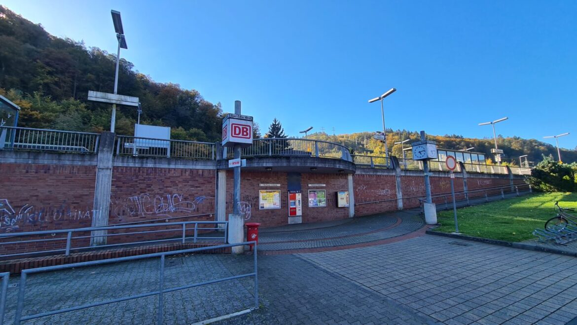 Eingang zu einem Bahnhof mit rotem DB-Logo und Informationstafeln.