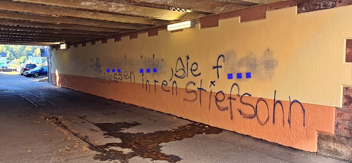 Graffiti in einer Unterführung mit unleserlichem Text.