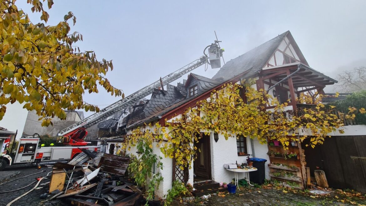 Feuerwehr löscht Brand in einem Haus mit beschädigtem Dach.