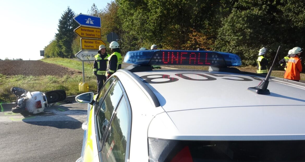 Verkehrsunfall mit Polizeiwagen und umgestürztem Roller auf Landstraße.