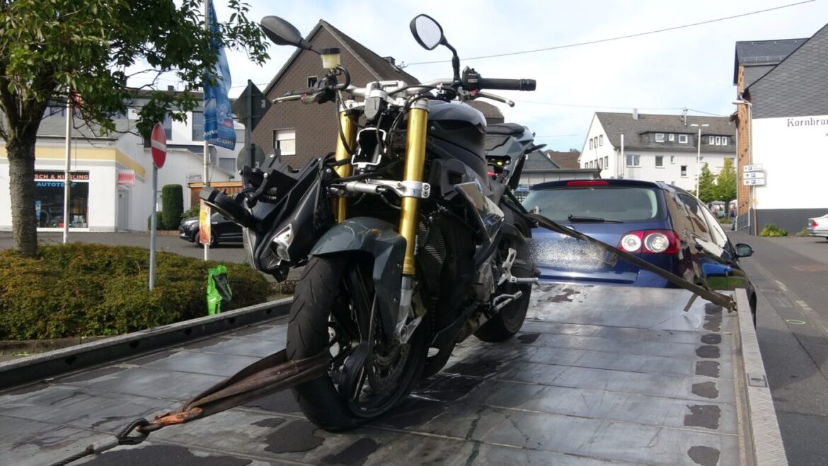 Motorrad auf einem Abschleppwagen in einer städtischen Umgebung.