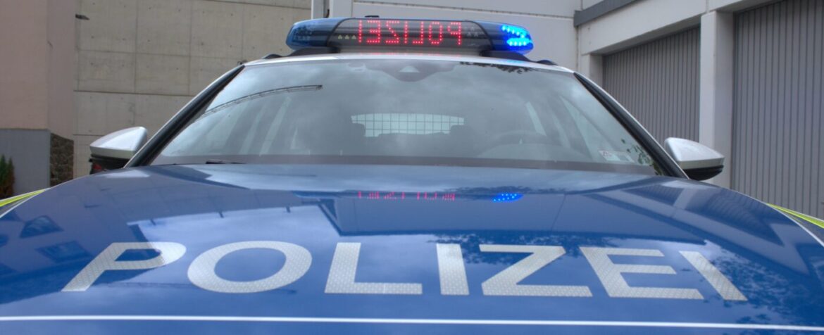Frontansicht eines Polizeiautos mit eingeschaltetem Blaulicht.