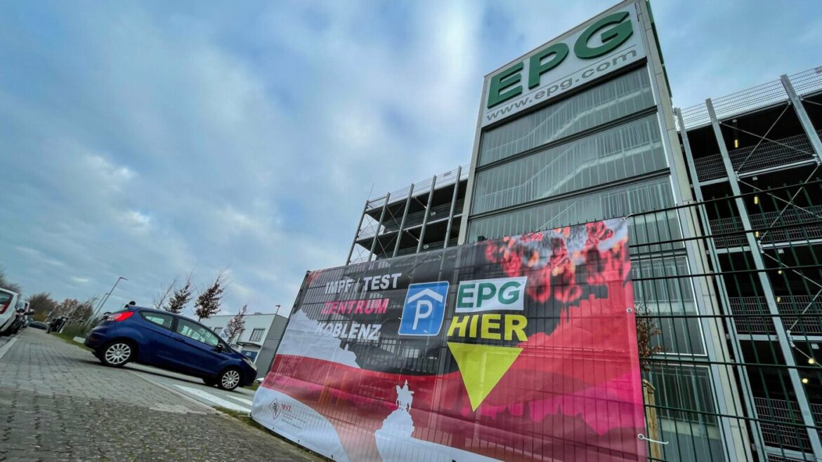 EPG-Parkhaus mit Werbebanner und Auto im Vordergrund.