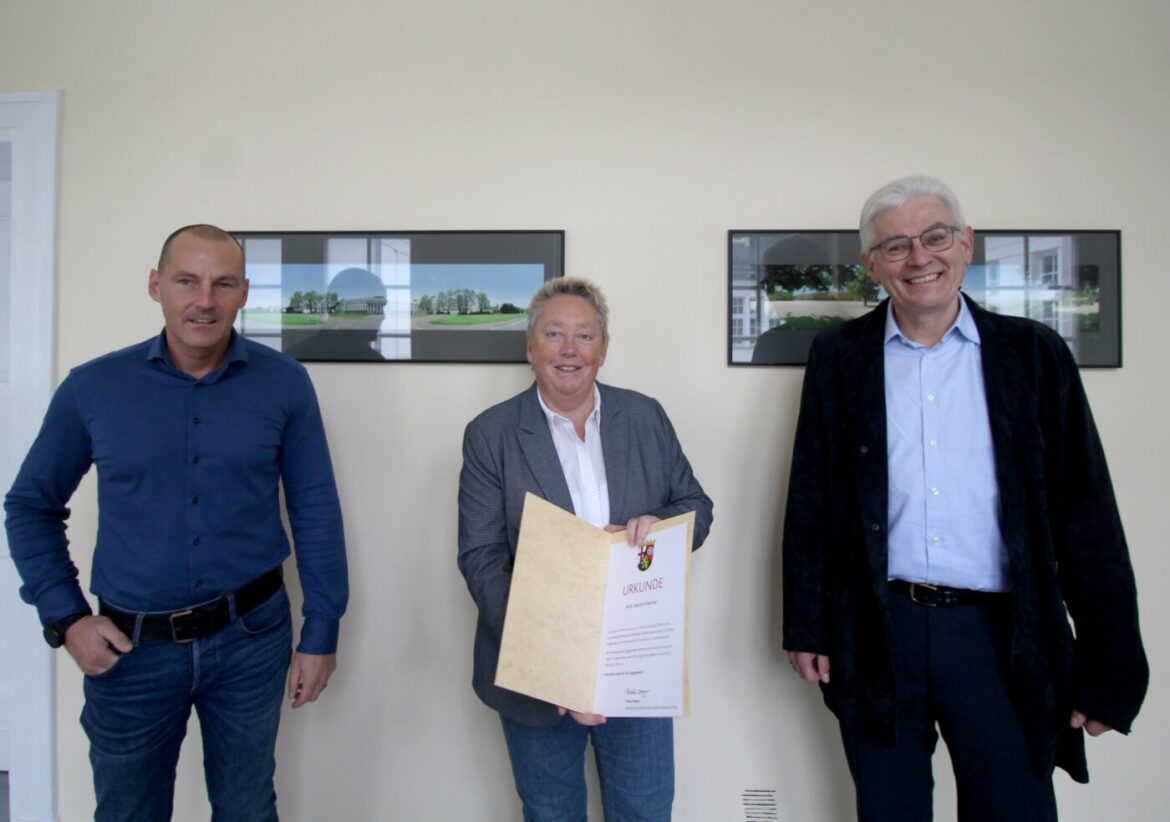 Drei Personen bei einer Ehrung im Labor Koblenz.