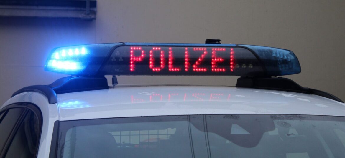 Polizeiauto mit eingeschaltetem Blaulicht und leuchtendem Schriftzug.