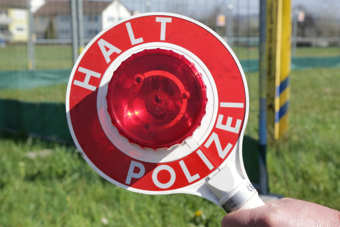 Polizeikelle mit rotem Licht und Aufschrift 'Halt Polizei'.