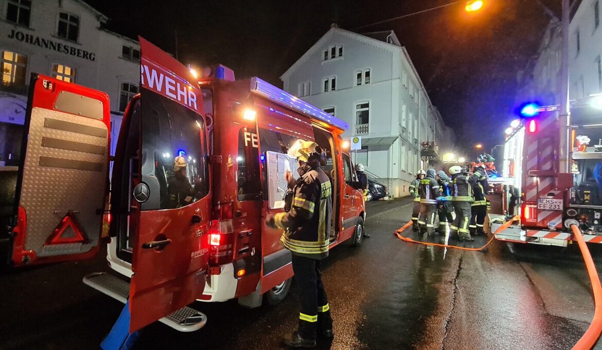 Feuerwehrleute bei einem nächtlichen Einsatz mit Löschfahrzeugen.