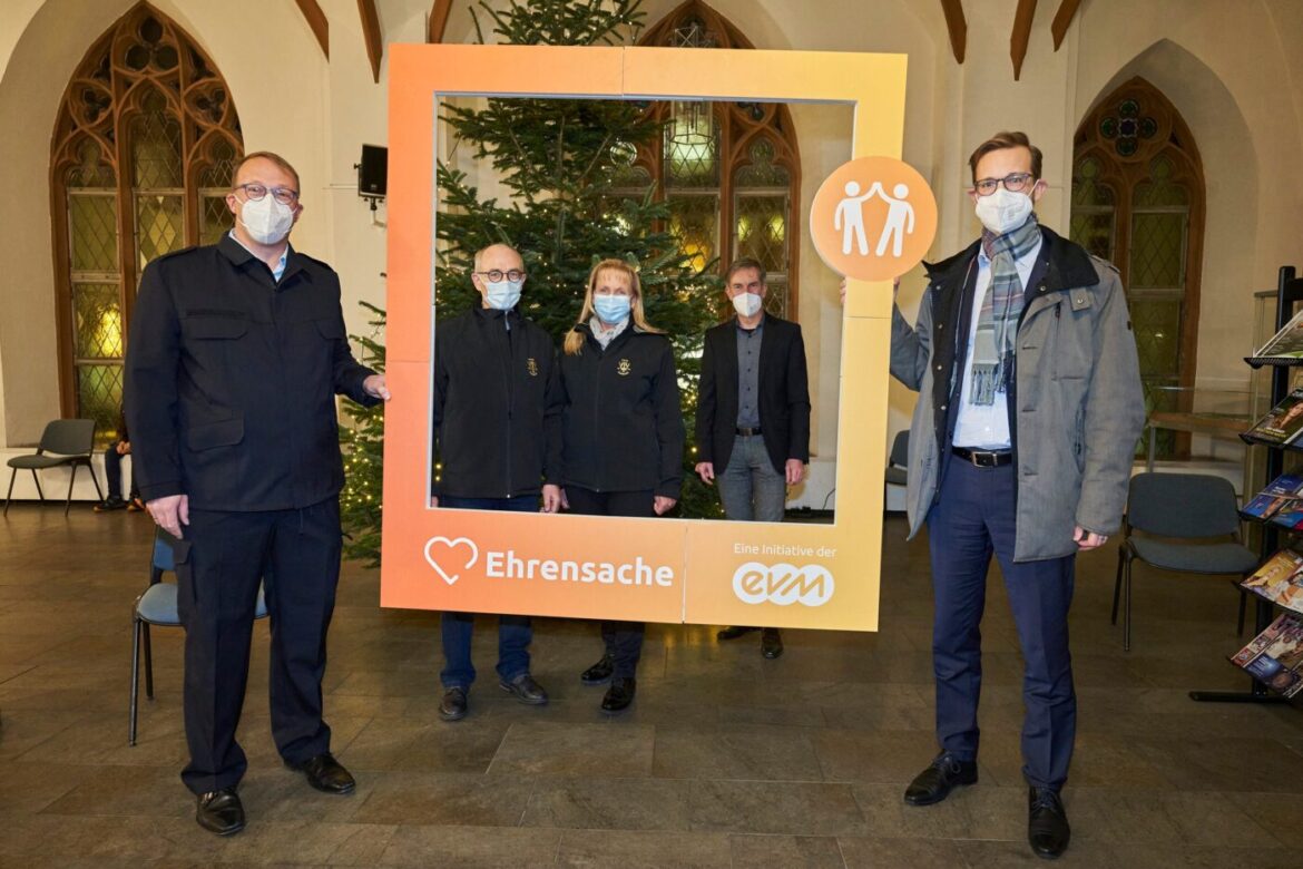 Gruppe von fünf Personen mit einem großen Bilderrahmen in einer Kirche.