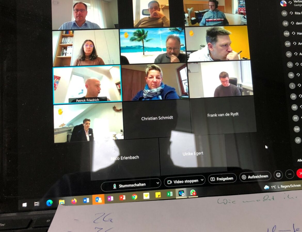 Videokonferenz mit mehreren Teilnehmern auf einem Laptop-Bildschirm.