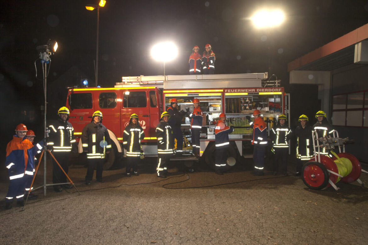 Jugendfeuerwehr bei Nachtübung mit Feuerwehrauto.