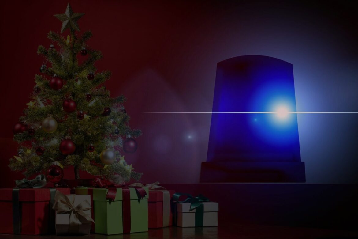 Weihnachtsbaum mit Geschenken und Blaulicht im Hintergrund