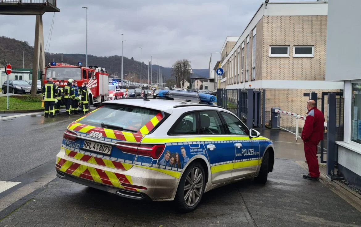 Polizeiauto und Einsatzkräfte bei einem Einsatz vor einem Gebäude.