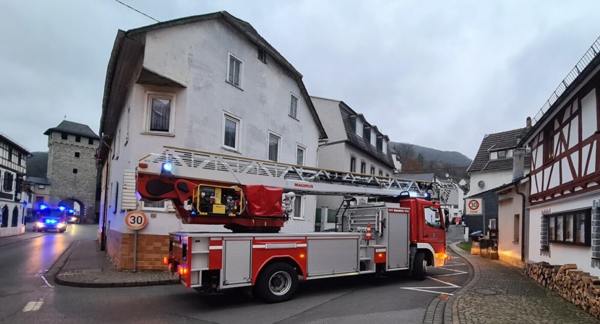 Feuerwehrfahrzeug mit Leiter in einer engen Straße.