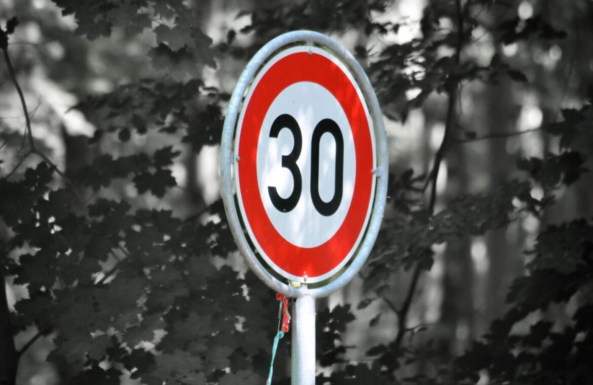 Verkehrsschild mit Tempo 30 in einer Straße.