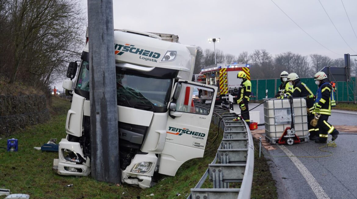 Lkw-Unfall auf nasser Straße mit Feuerwehr im Einsatz.