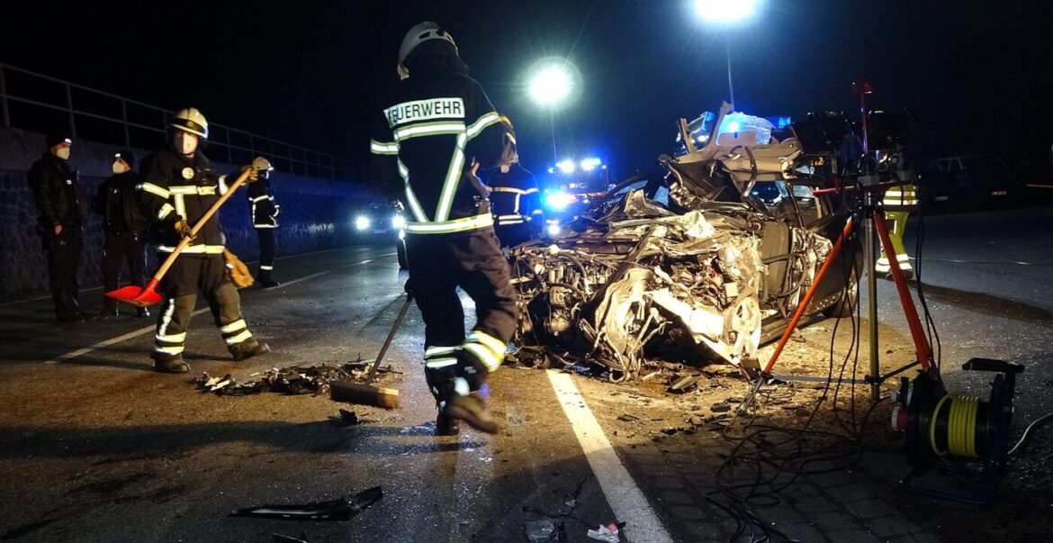 Feuerwehrleute räumen nach einem nächtlichen Autounfall auf.