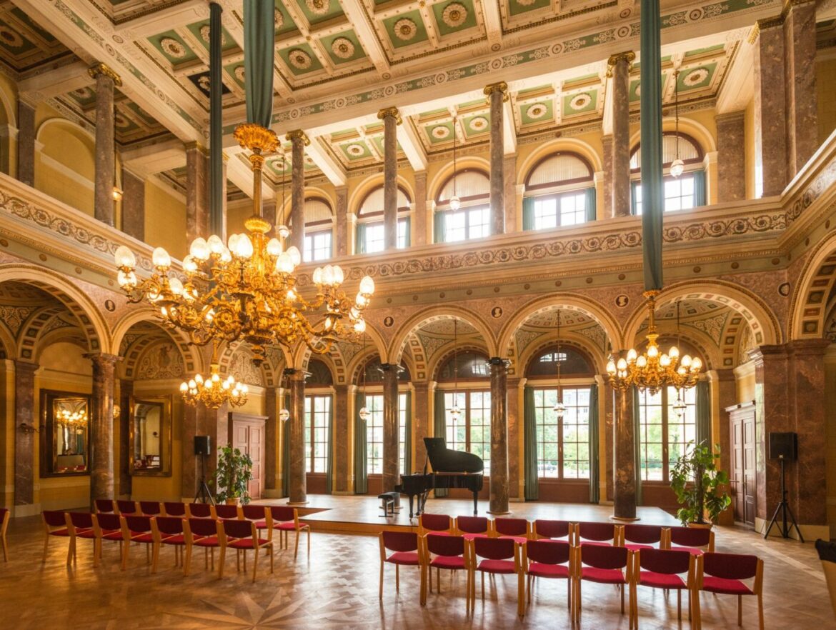 Eleganter Marmorsaal mit Kronleuchtern und Flügel