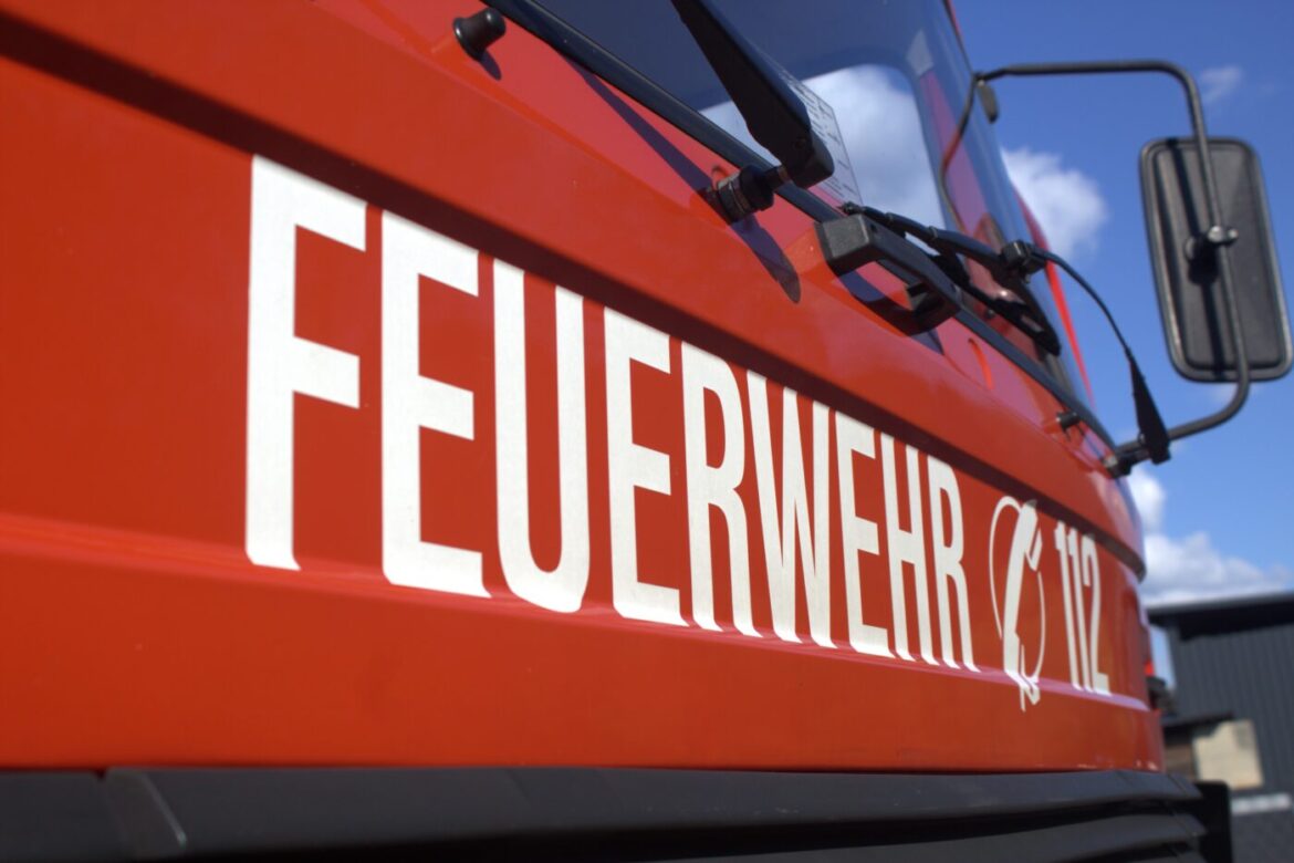 Nahaufnahme eines roten Feuerwehrfahrzeugs mit der Aufschrift „FEUERWEHR 112“.