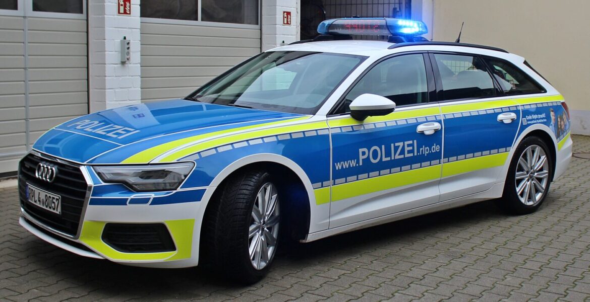 Ein Polizeiauto der Marke Audi in blau-weiß mit Leuchtsignal und Internetadresse auf der Seite.