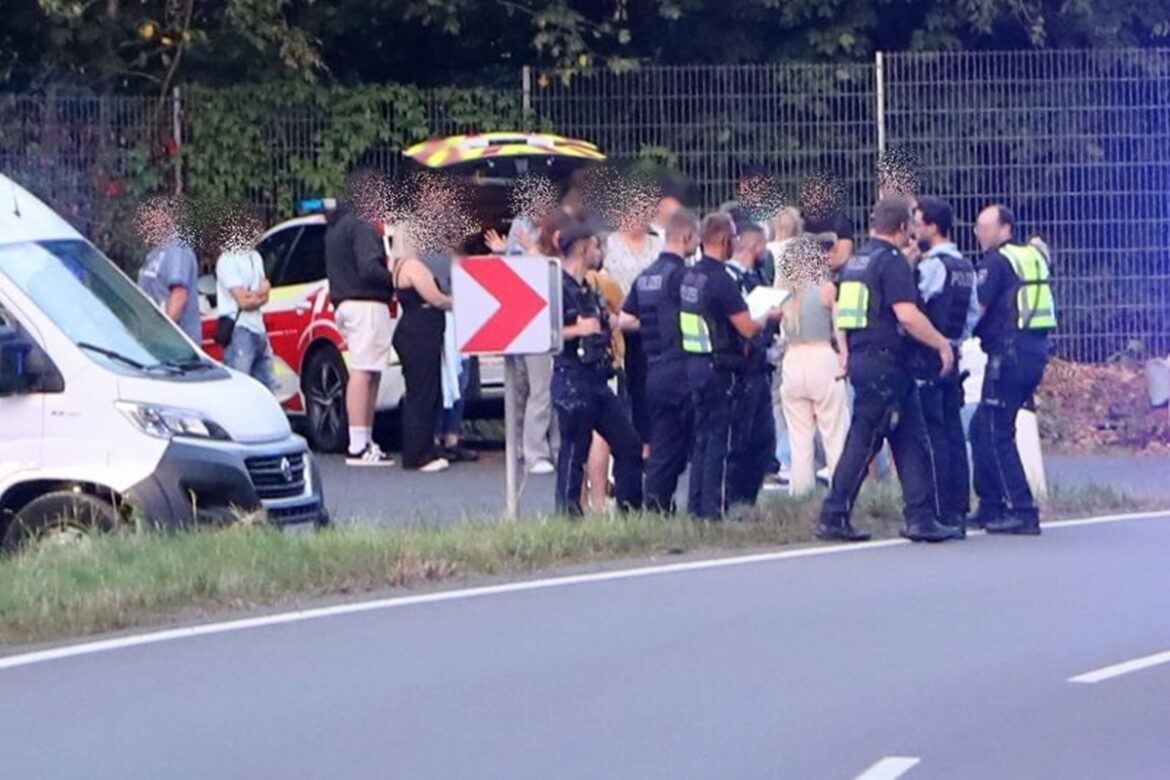 Messerangriff-Bus-Siege-Stadtfest-4 Eine Polizeikontrolle an einer Straße mit mehreren Beamten und einer Gruppe von Beteiligten.
