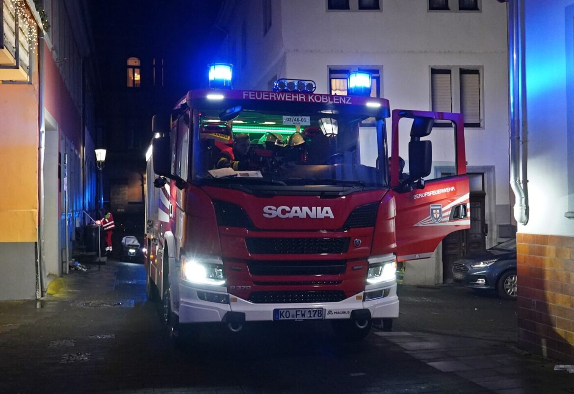Feuerwehrauto der Feuerwehr Koblenz in einer schmalen Gasse bei Nacht.