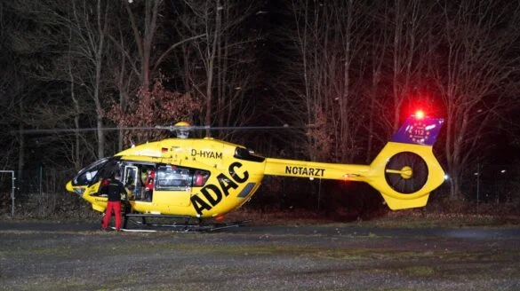 4_56aktuell Gelber ADAC-Rettungshubschrauber bei Nacht im Wald.