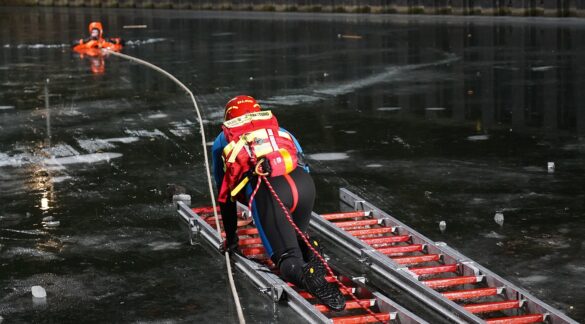 56aktuell_3YF7mQ1G Rettungskräfte üben auf einem gefrorenen See mit Leiter und Seil.
