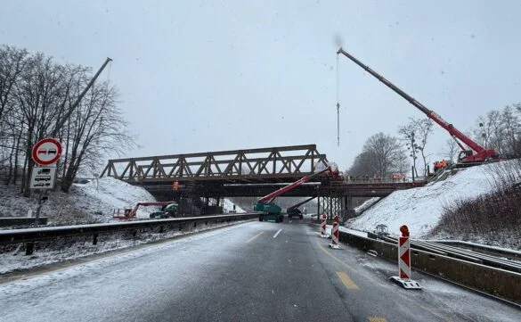 56aktuell_E0NjjCwp Bauarbeiten an einer Brücke im Winter mit Kränen und Schnee.