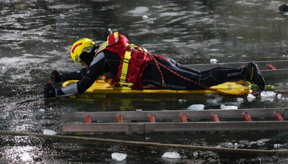 56aktuell_OOO0V0r0 Rettungspersonal in Schutzkleidung rettet Person auf gefrorenem See.