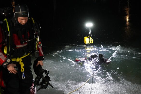 56aktuell_XRPGRIkK Taucher bei Nacht im gefrorenen See mit Beleuchtung