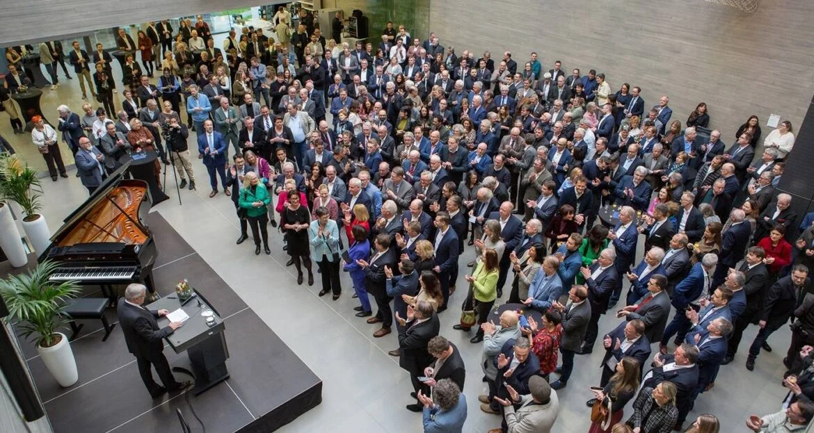 Menschenmenge bei einer Veranstaltung mit Redner und Flügel