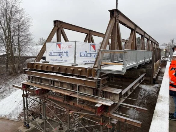 56aktuell_xBtmtN1b Brücke im Bau mit Gerüst und Werbebanner im Winter.