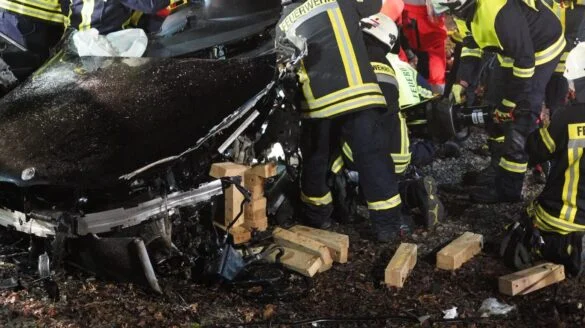 5_56aktuell Rettungskräfte arbeiten an einem Unfallort mit beschädigtem Fahrzeug.