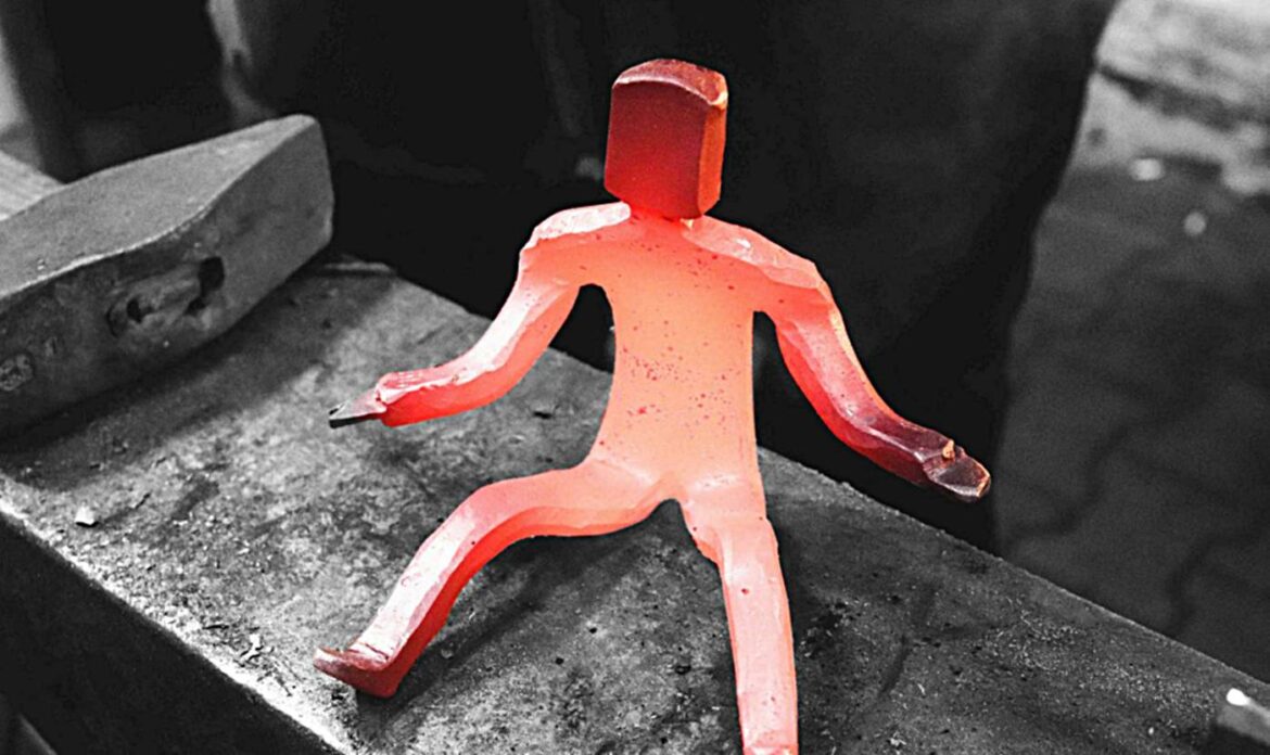 Glühende Metallfigur auf einem Amboss