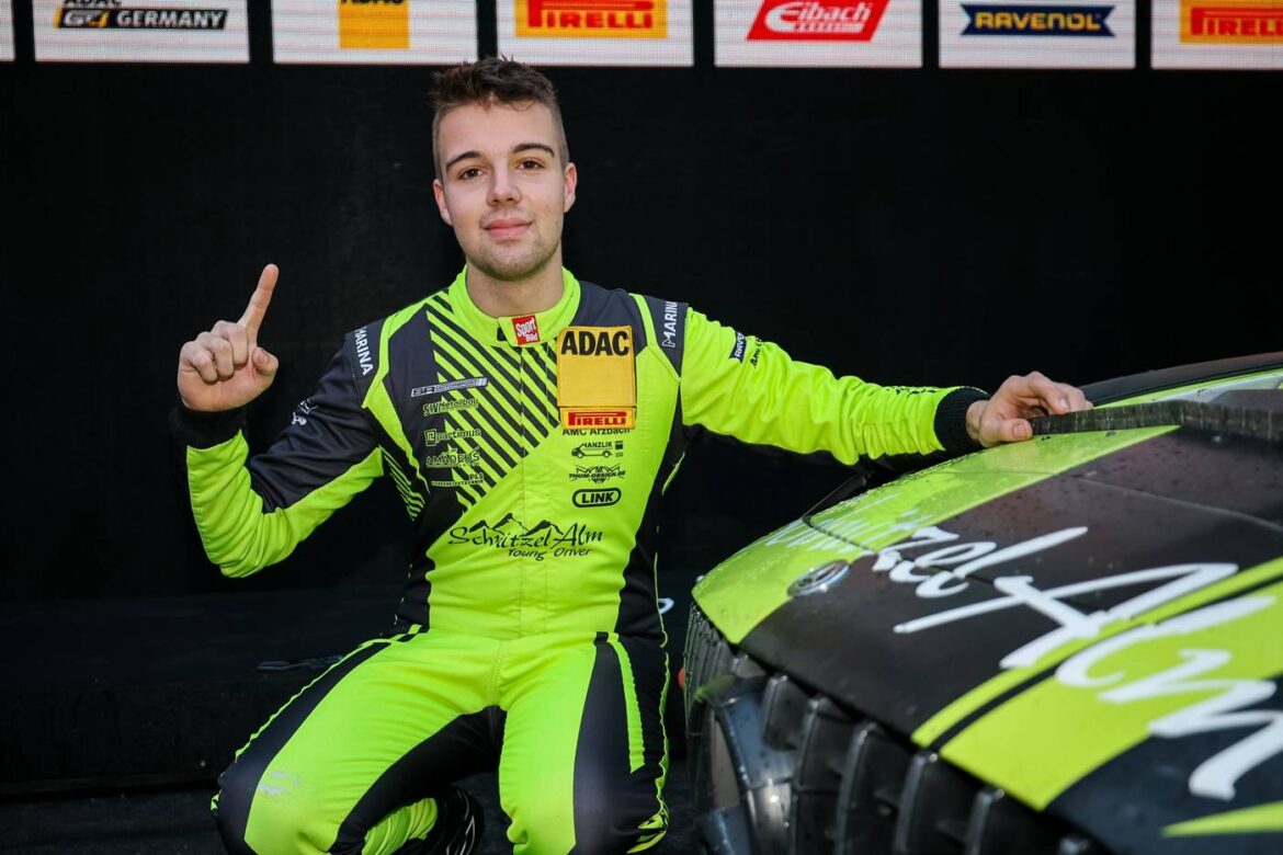 Junger Rennfahrer in leuchtend grünem Anzug neben einem Rennwagen.