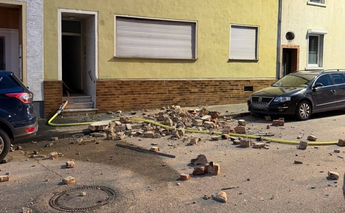 Ziegelsteine und Trümmer auf der Straße vor einem Gebäude.