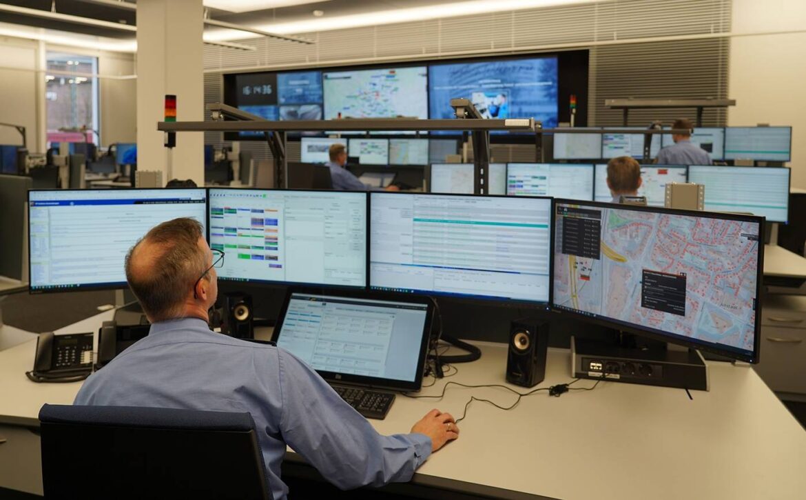 Mitarbeiter in Leitstelle mit mehreren Bildschirmen.